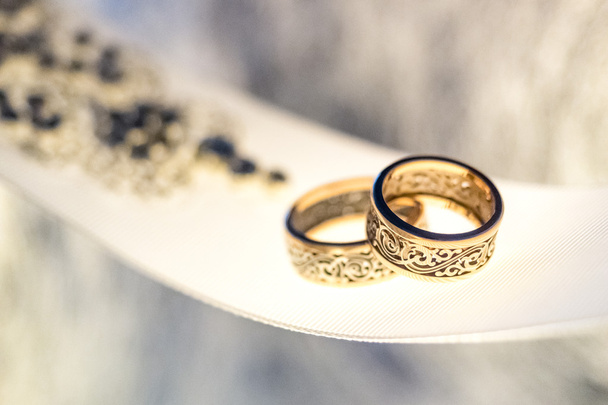 Dos anillos de boda con diseño raro en cinta ancha blanca
 - Foto, Imagen