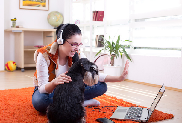 Girl with dog using video call on laptop - Photo, Image