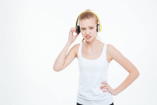 Unhappy stressed young woman removing yellow headphones  - Фото, изображение