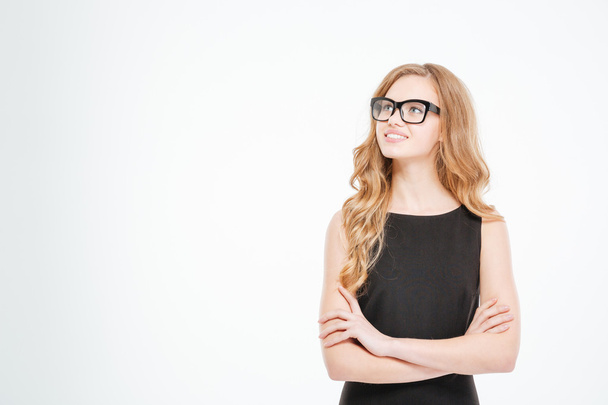Smiling cute young business woman in glasses standing and thinking  - Fotoğraf, Görsel