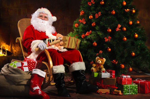 Santa Claus sitting in front of fireplace - Foto, Imagem