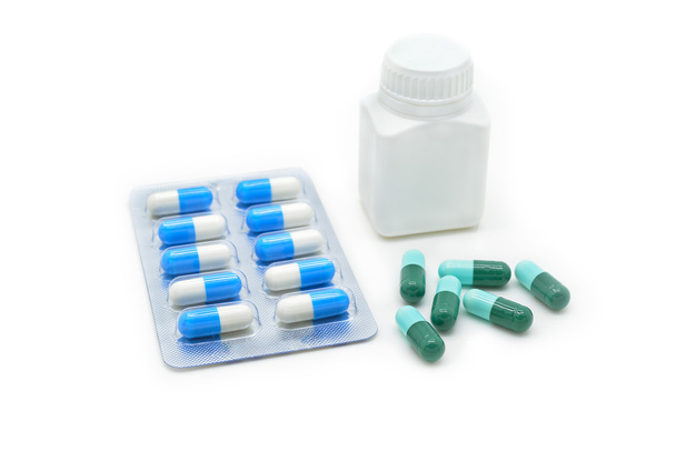 Cápsulas de medicamento com frasco branco
 - Foto, Imagem