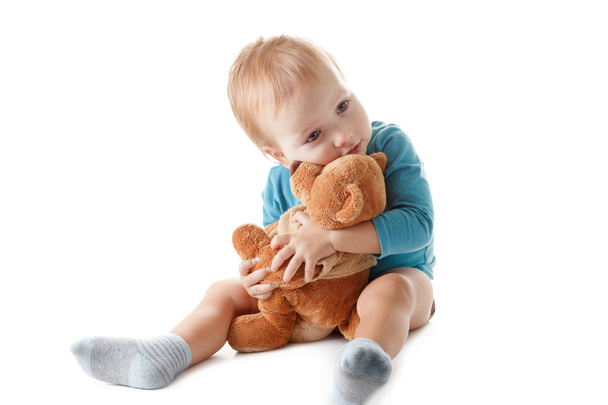 Little boy hugging a teddy bear on white background - Foto, imagen