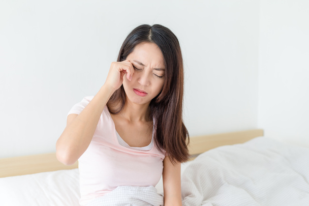 Kadın duygu baş ağrısı ve yatak üzerinde oturan - Fotoğraf, Görsel