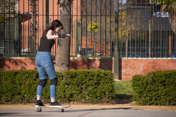 Beautiful young woman practicing with the skateboard on the stre - 写真・画像