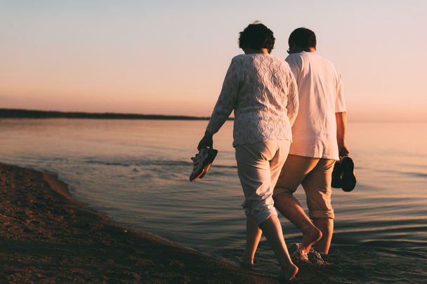 Adult couple walks on the seashore. - Foto, imagen