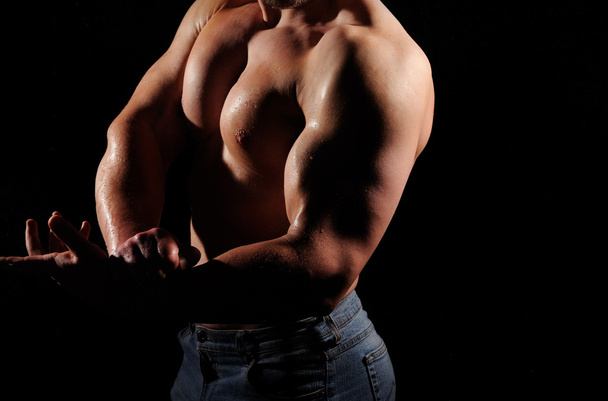 Muscular male posing on black background - Photo, Image