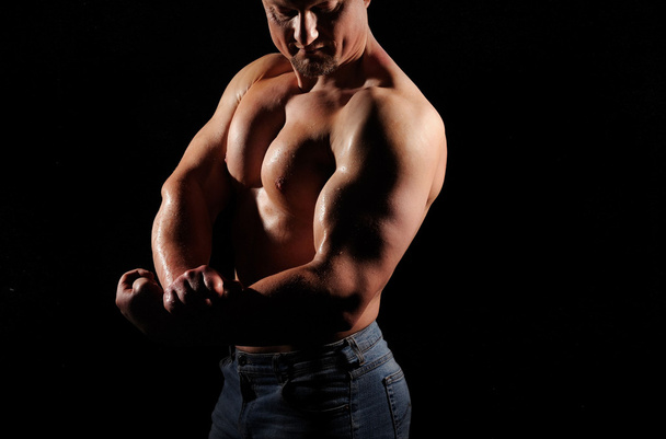 Muscular male posing on black background - Фото, изображение