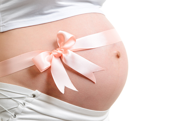 Schwangerschaftsbauch mit rosa Schleife. - Foto, Bild