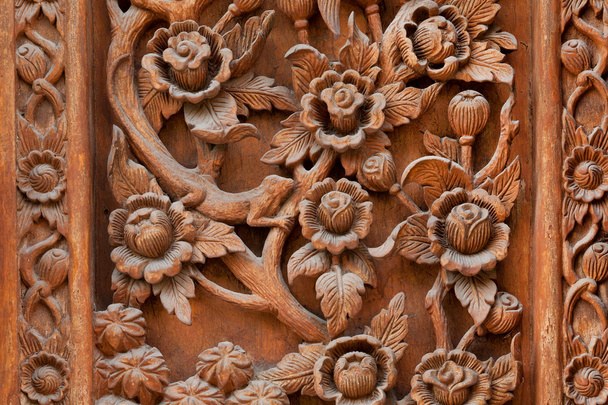 Λουλούδια λαξευμένα σε ξύλινο πίνακα της αρχαίας πόρτας - Φωτογραφία, εικόνα