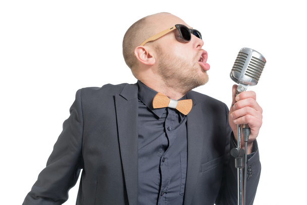 Unshaven bald man with microphone - Foto, afbeelding