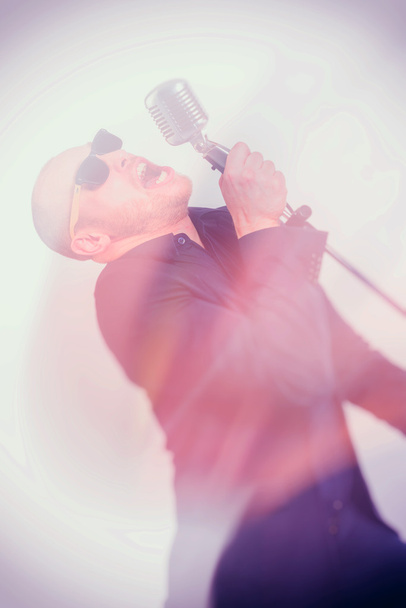 Unshaven bald man with microphone - Foto, Imagen