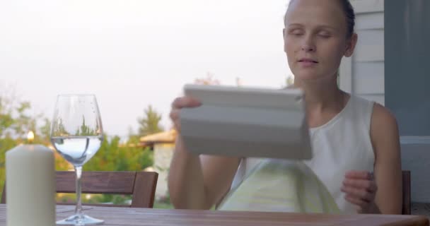 Mujer usando almohadilla y agua potable en terraza al aire libre
 - Imágenes, Vídeo