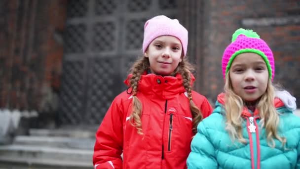 Dvě malé holčičky chodí kolem baziliky v Gdaňsku - Záběry, video