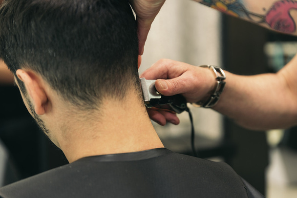 Hairstylist making men's haircut to an attractive man. - Valokuva, kuva
