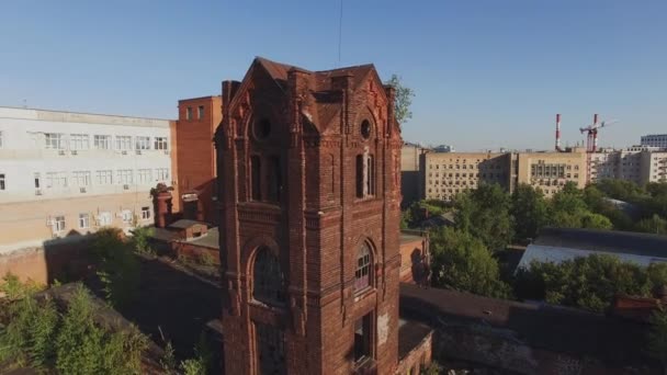 Quadrocopter strzelać opuszczony kaplicy na dachu starego budynku z cegły w mieście. Słoneczny dzień lata - Materiał filmowy, wideo