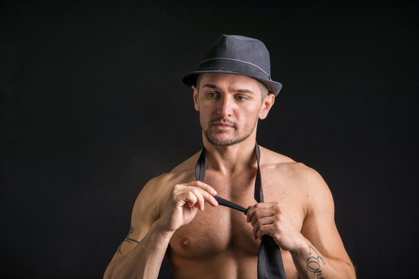 Muscular man wearing jeans, hat and neck-tie - Foto, Imagem