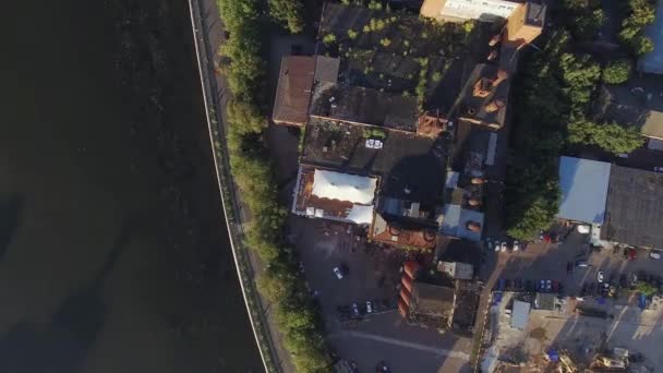 Quadrocopter 白いテントとサマー レストランの屋根上に飛ぶ。川で古い建物。晴れた日 - 映像、動画