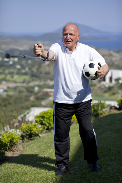 Retired football player with walking stick holding a soccerball - Zdjęcie, obraz