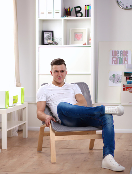 Молодой бизнесмен работает в офисе, сидит за столом - Фото, изображение