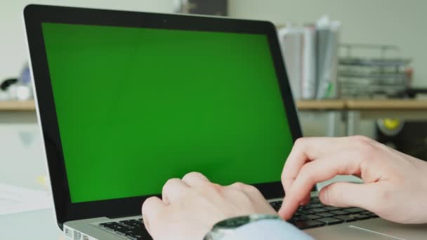 Liikemies kirjoittaa kannettavan tietokoneen vihreällä näytöllä lasipöydällä toimistossa
 - Materiaali, video
