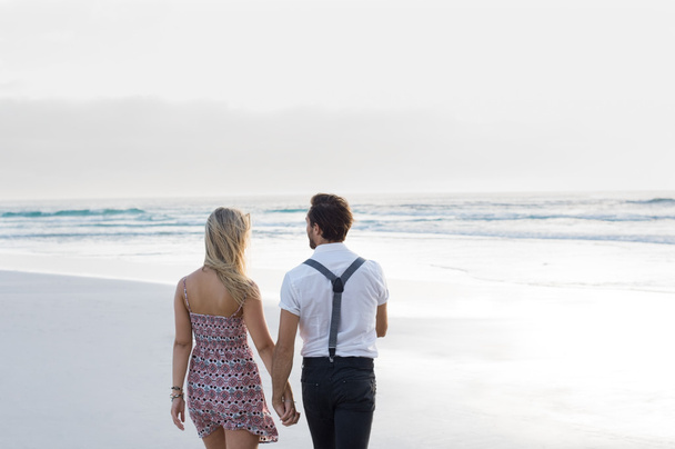 Couple walking on seashore - Фото, зображення
