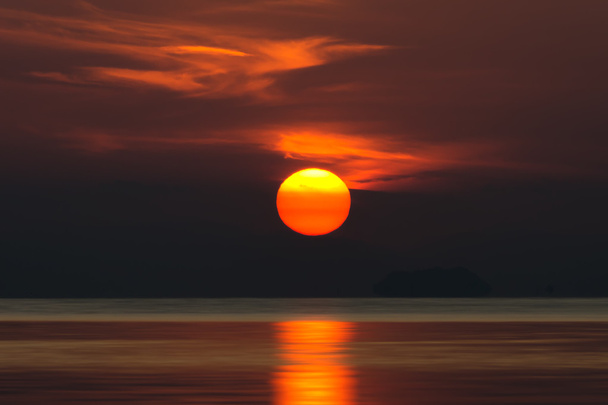 Grande sole e nube arancione nel cielo del tramonto sul lago
. - Foto, immagini