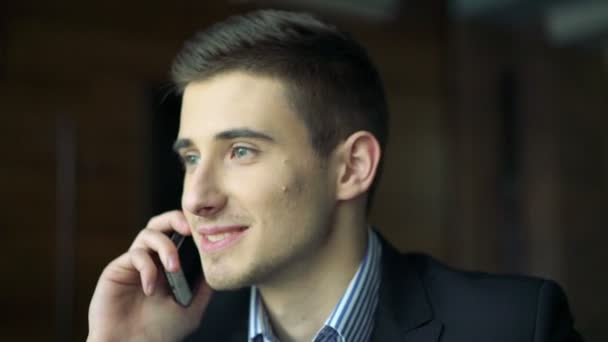 Handsome boy speaking on the phone in cafe - Felvétel, videó