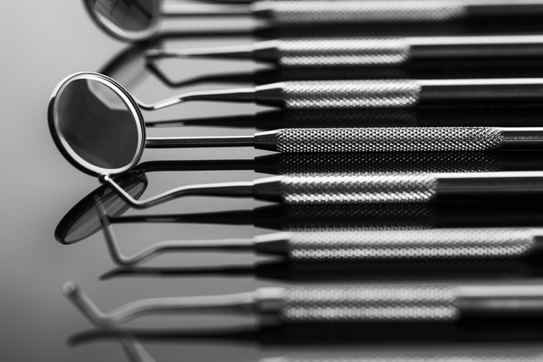 Крупный план профессиональных стоматологических инструментов на блестящем столе
 - Фото, изображение