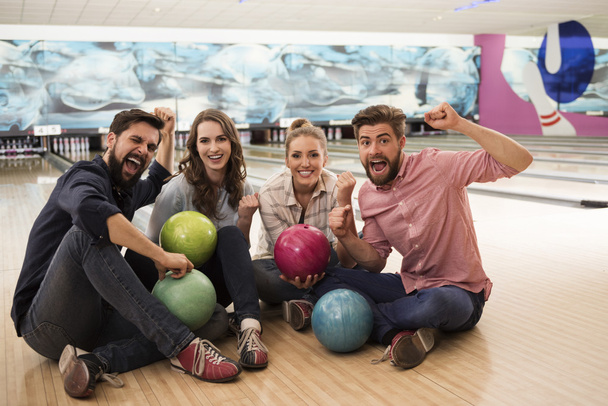 Friends playing bowling game  - Фото, зображення
