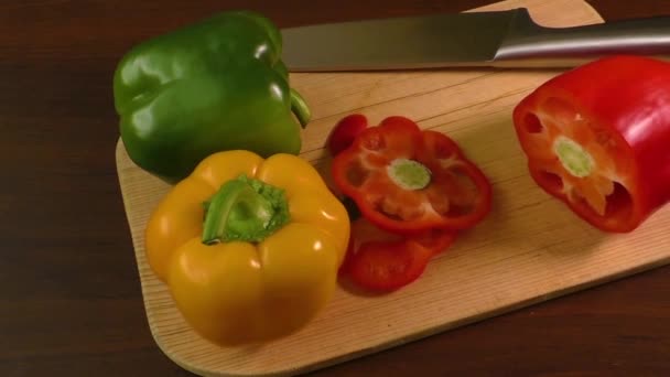 Cutting and preparing bell peppers on a cutting board, including red, yellow and green - Footage, Video