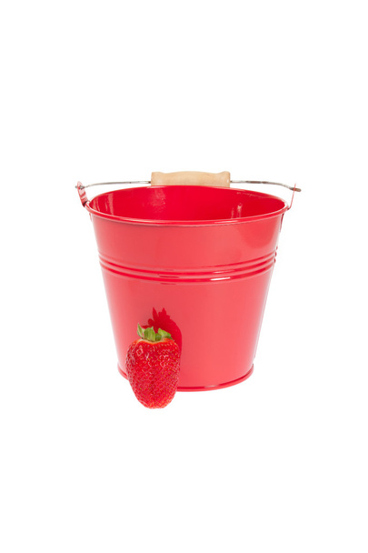 Empty sheet metal pail with a strawberry in front of white background - Foto, afbeelding