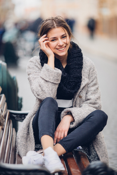 Pretty woman sitting on the bench and smile - Foto, Bild