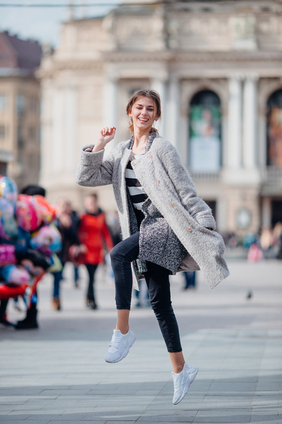 Young girl jumping on the city street - Valokuva, kuva