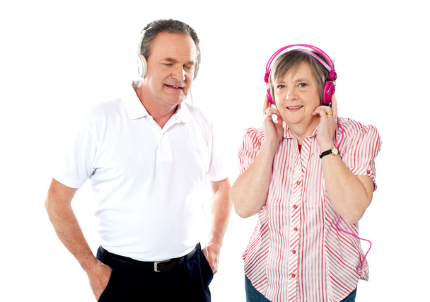 Happy aged couple enjoying music together - Foto, afbeelding