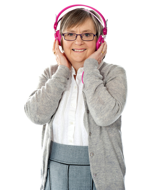 Attractive old lady wearing headphones - Фото, изображение