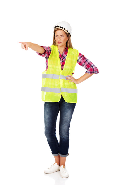 Smiling female builder in vest - Фото, изображение