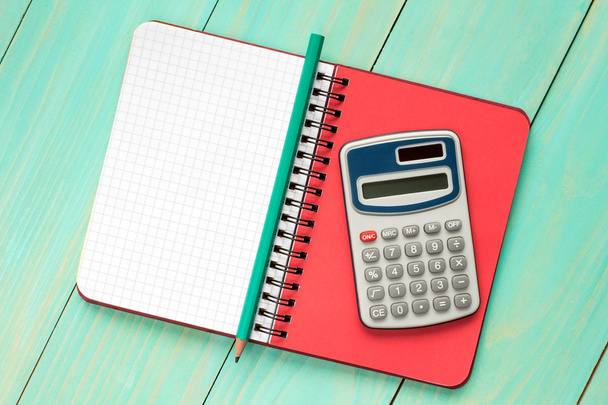   Electronic calculator and notebook. - Фото, изображение