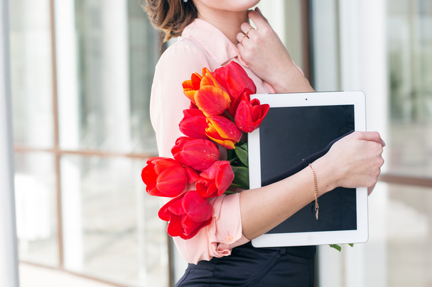 Beautiful girl with tablet and flowers - Valokuva, kuva
