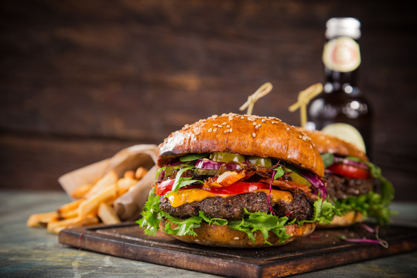 Tasty burgers on wooden table. - Fotó, kép
