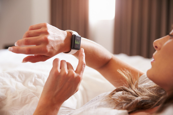 Frau überprüft Fitness-App auf Smartwatch - Foto, Bild