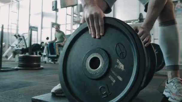 ボディービルダー選手がバーベルの重量を置く - 映像、動画