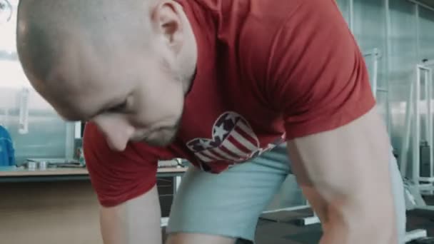 L'atleta bodybuilder fissa il peso del bilanciere su una barra
 - Filmati, video