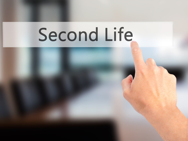 Second Life - Hand indrukken van een knop op de onscherpe achtergrond conce - Foto, afbeelding
