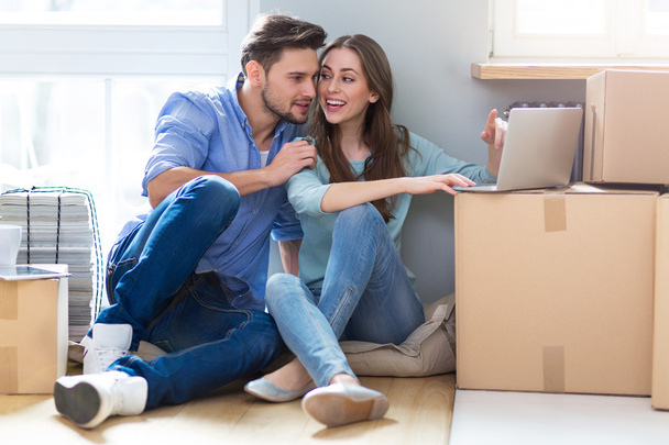Couple with unpacked boxes in new home - Photo, Image