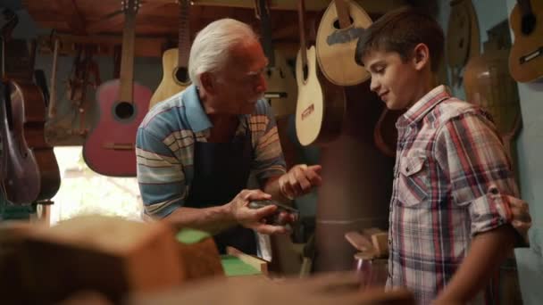 7-Old Lute Maker Enseñando Nieto Niño Chiseling Madera
 - Metraje, vídeo
