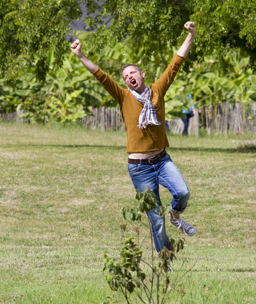 crazy 40s man running for freedom in sunny outdoors - Foto, Imagem