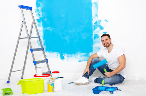 happy man doing repairs, paint wall at home - Valokuva, kuva