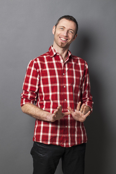 excited 40s man with checked shirt pointing finger to show something on side - Foto, afbeelding