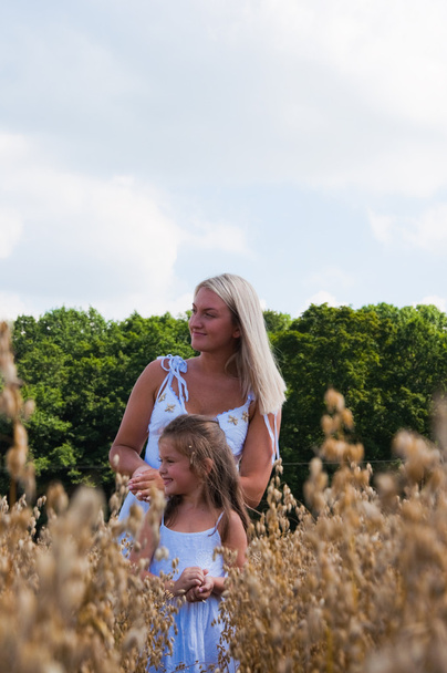 Mother and daughter playing at corn - Fotoğraf, Görsel